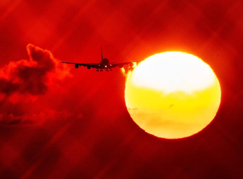 An aircraft passes the rising sun as it approaches the airport in Frankfurt, Germany.  AP