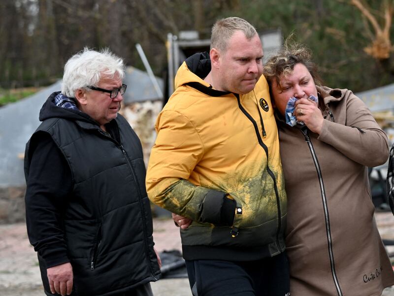 A Ukrainian mother is comforted by relatives after the body of her son was discovered in a manhole in Buzova village, west of Kyiv. AFP