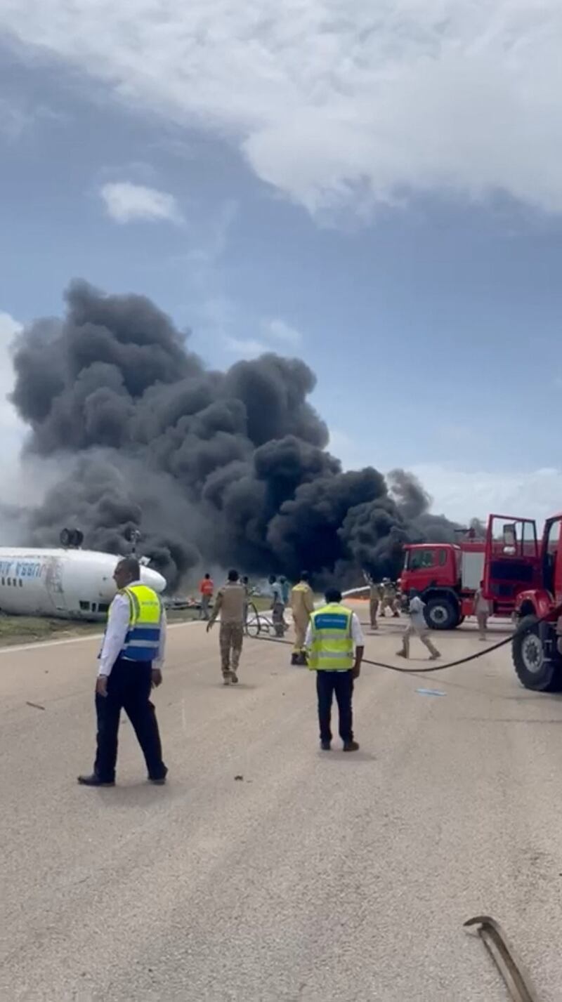 Smoke billows from a plane that flipped over after a crash landing, in Mogadishu, Somalia in this picture obtained from social media. Photo: Abdirahman Mohamed Arab via Reuters