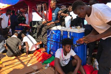 Rescued migrants wait aboard the 'Ocean Viking' rescue ship, jointly operated by French NGOs SOS Mediterranee and Medecins sans Frontieres (MSF Doctors without Borders) on August 20, 2019, at sea between Malta and Lampedusa, after a search-and-rescue operation in the Mediterranean Sea. The Ocean Viking rescue ship, with 356 migrants on board waits since August 14, 2019 for a safe port to dock. / AFP / Anne CHAON