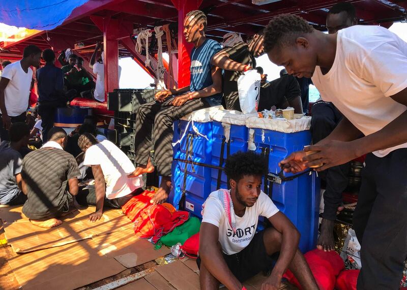 Rescued migrants wait aboard the 'Ocean Viking' rescue ship, jointly operated by French NGOs SOS Mediterranee and Medecins sans Frontieres (MSF Doctors without Borders) on August 20, 2019, at sea between Malta and Lampedusa, after a search-and-rescue operation in the Mediterranean Sea. The Ocean Viking rescue ship, with 356 migrants on board waits since August 14, 2019 for a safe port to dock. / AFP / Anne CHAON

