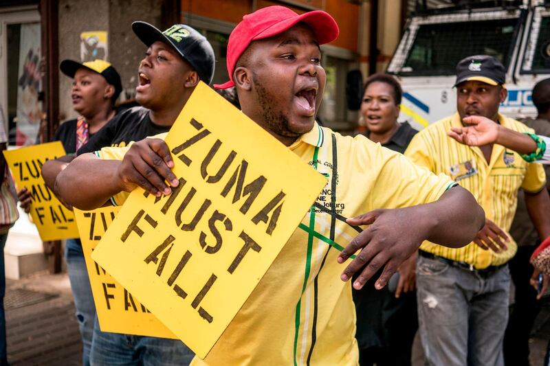 TOPSHOT - Supporters of the African National Congress Deputy President Cyril Ramaphosa hold placards and chant slogans outside the ANC party headquarter in Johannesburg, on February 5, 2018, during a demonstration to protest against South African President and ANC member Jacob Zuma.
Senior members of South Africa's ANC party will hold an emergency meeting Monday to discuss whether President Jacob Zuma should stay in office after he reportedly refused to resign. Some African National Congress (ANC) members are pushing for Cyril Ramaphosa, the new head of the party, to replace Zuma as president immediately. / AFP PHOTO / MARCO LONGARI