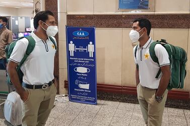 Pakistani cricketers Sarfaraz Ahmed, left, and Asad Shafiq wearing facemasks arrive at the Allama Iqbal International airport in Lahore before their departure to England on June 28. AFP