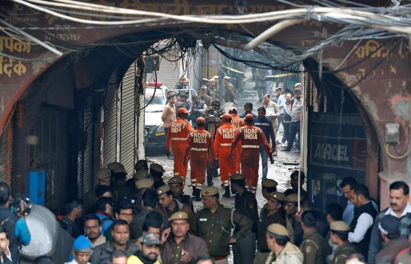 Members of India's National Disaster Response Force (NDRF) head towards the site of a fire that swept through a factory where laborers were sleeping, in New Delhi, India.  Reuters