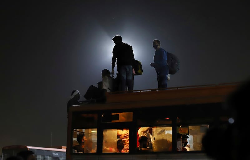 Migrant workers leave for their villages from a bus terminal in New Delhi. AP Photo