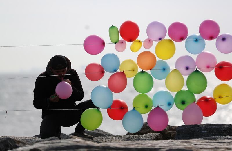 A man hangs balloons on strings near the Bosphorus in Istanbul, Turkey.  EPA