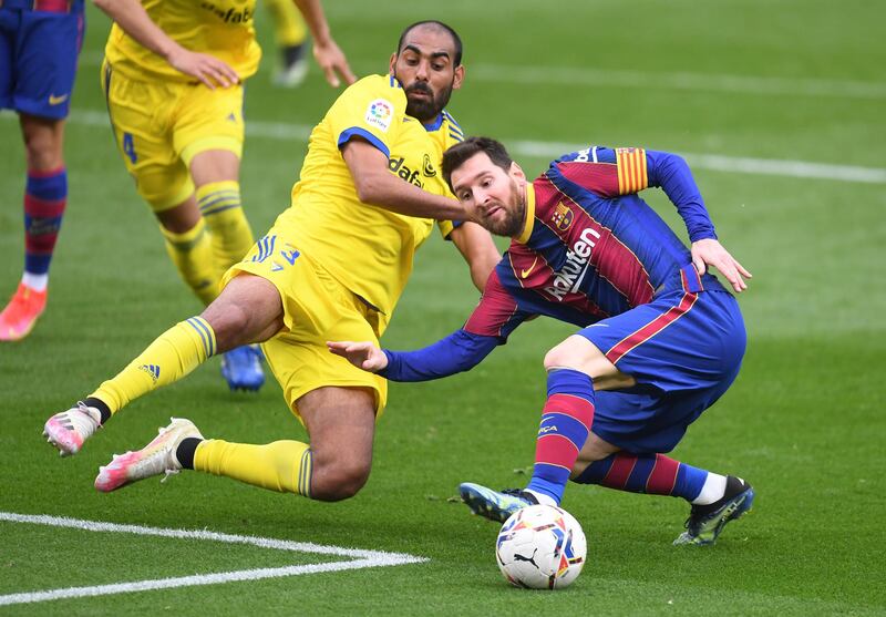 Barca's Lionel Messi is challenged by Fali of Cadiz. Getty