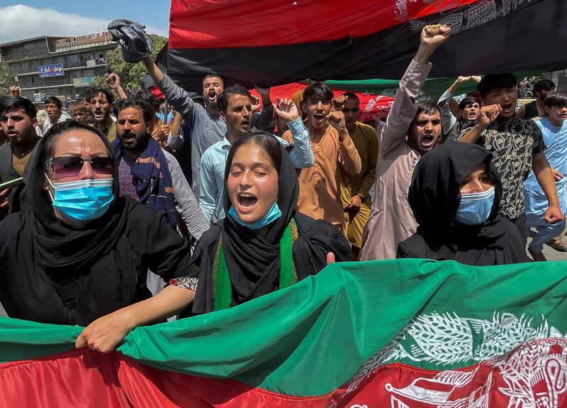 People carry the national flag as they take part in an anti-Taliban protest held during Afghanistan's Independence Day, in Kabul, on August 19. Reuters