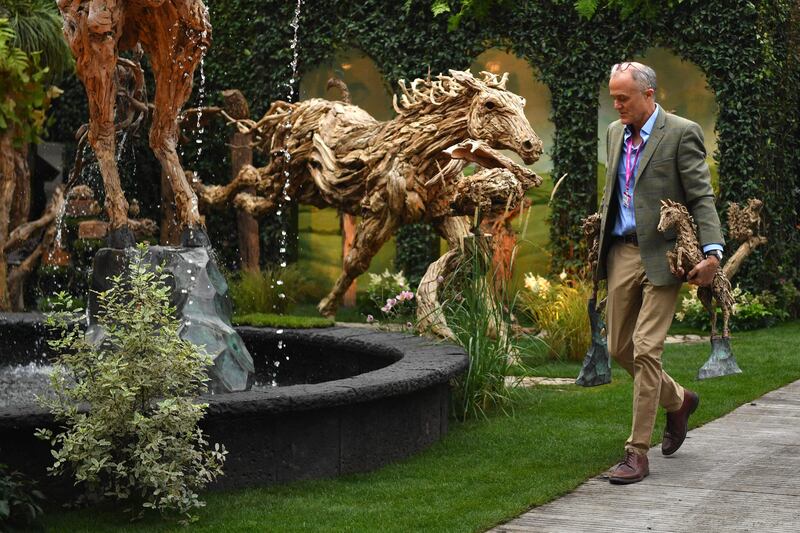 Finishing touches are made to a driftwood sculpture. This year marks the first time the event has been held in autumn. AFP