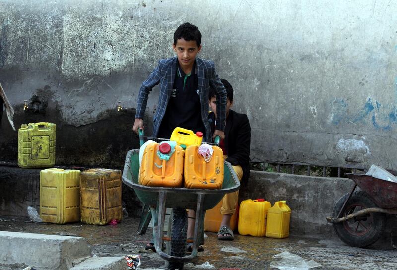 A Yemeni pushes a wheelbarrow with canisters full of drinking water from a water pipe on the roadside on World Water Day in Sanaa, Yemen.  EPA