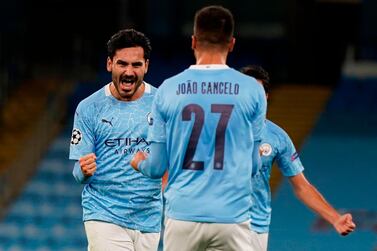 Manchester City's German midfielder Ilkay Gundogan (L) celebrates scoring their second goal from a free kick during the UEFA Champions League football Group C match between Manchester City and Porto at the Etihad Stadium in Manchester, north west England on October 21, 2020. / AFP / POOL / Tim Keeton