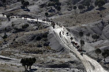 Afghans walk with camels on a dusty road near the town of Walli Was in Paktika province, near the border with Pakistan November 3, 2012. Reuters