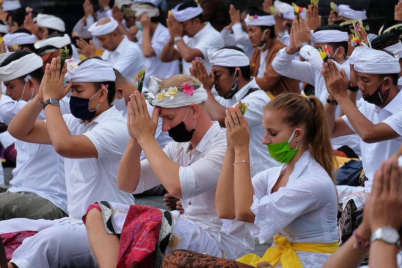 People attend mass prayers, expressing gratitude for the handling of the new coronavirus and seeking blessings for the start of a "new normal", at Besakih temple in Karangasem, Bali, Indonesia, July 5, 2020 in this photo taken by Antara Foto.  Antara Foto/Nyoman Hendra Wibowo/ via REUTERS ATTENTION EDITORS - THIS IMAGE WAS PROVIDED BY A THIRD PARTY. MANDATORY CREDIT. INDONESIA OUT.