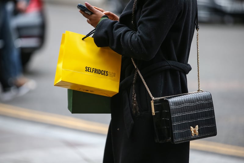 A shopper carries a shopping bag outside Harrods luxury department store on April 22, 2022 in London, England. Hollie Adams / Getty Images)
