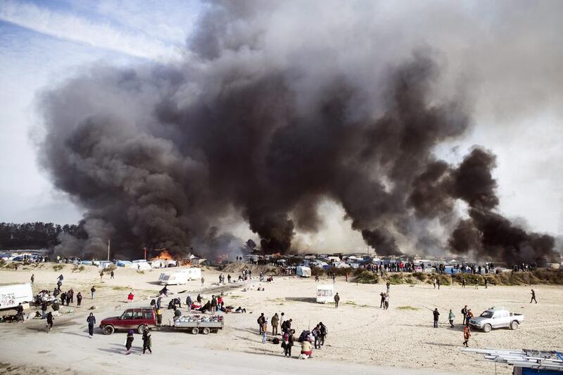 Smoke billows from the camp near Calais after tents and shelters were set ablaze on October 26, 2016. Etienne Laurent/EPA