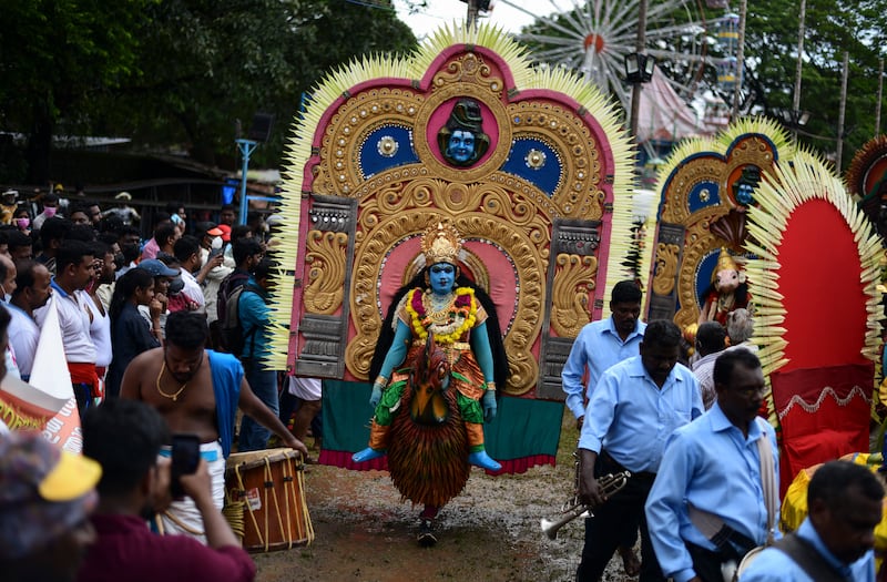 Artists dressed up like Hindu deities participate in the Athachamayam procession in Kochi. AP