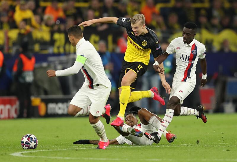 DORTMUND, GERMANY - FEBRUARY 18: Erling Haaland of Borussia Dortmund is challenged by Thiago Silva, Presnel Kimpembe and Idrissa Gueye of Paris Saint-Germain during the UEFA Champions League round of 16 first leg match between Borussia Dortmund and Paris Saint-Germain at Signal Iduna Park on February 18, 2020 in Dortmund, Germany. (Photo by Lars Baron/Bongarts/Getty Images)