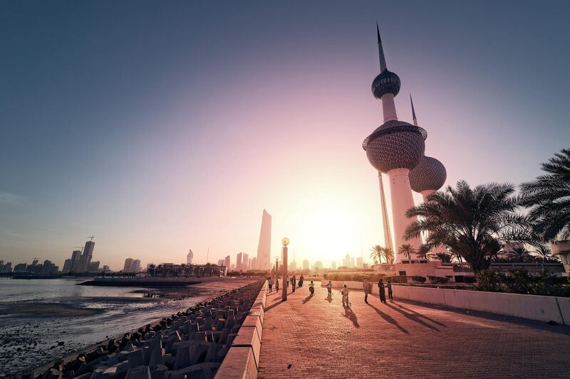View of Kuwait Towers with Kuwait City in the background at sunset.