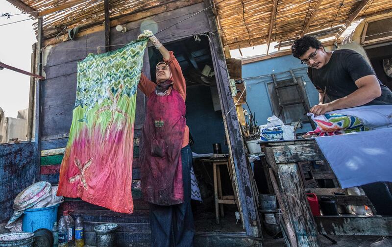 Samar Hassanein hangs painted fabric to dry at her workshop in the Al Fustat area of Old Cairo.
