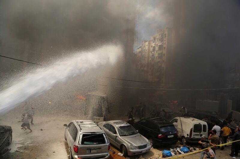 Civil Defence members extinguish fire at the site of an explosion in Beirut's southern suburbs July 9, 2013. At least 18 people were wounded by a car bomb blast in Beirut's southern suburbs on Tuesday, a stronghold of the Lebanese Shi'ite Hezbollah militant group that has been fighting in Syria's civil war, security sources said. The sources were unable to confirm initial reports from medics at the scene that an unspecified number were killed in the massive blast. REUTERS/Issam Kobeisi (LEBANON - Tags: POLITICS CIVIL UNREST) *** Local Caption ***  LBN14_LEBANON-EXPLO_0709_11.JPG
