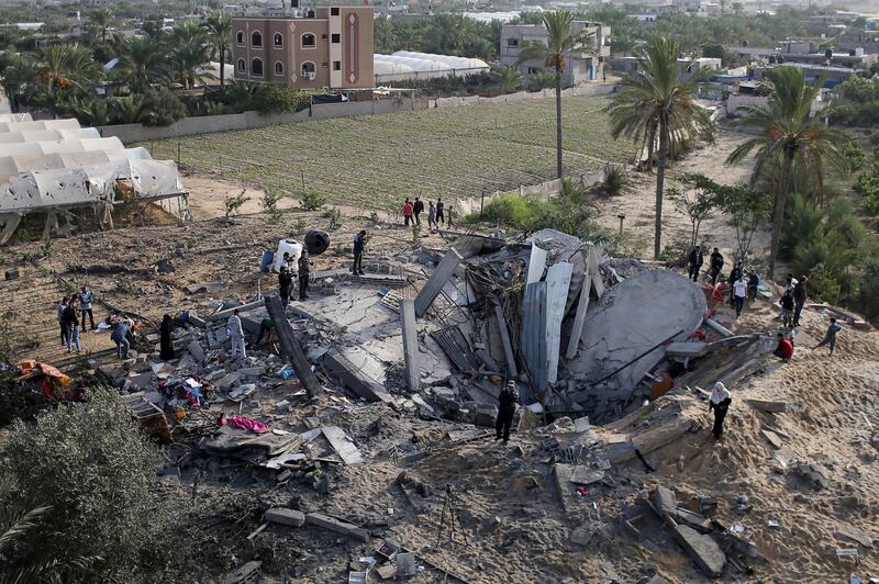 Palestinians gather around the remains of a house destroyed in an Israeli air strike in the southern Gaza Strip. Reuters