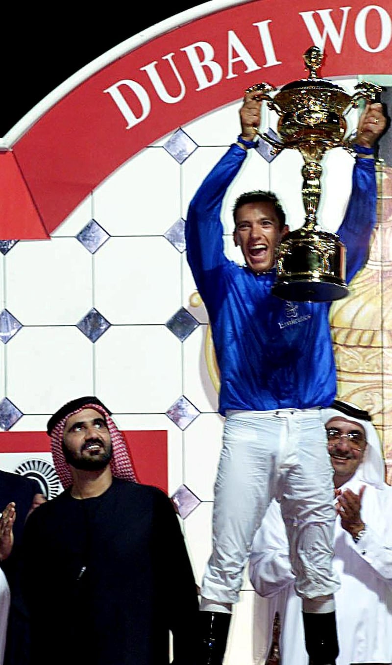 Jockey Frankie Dettori, hold the World Cup next to Sheikh Mohamed Bin Rashed Al-Maktoum, UAE Minister of Defence and Crown Prince of Dubai, and owner of Dubai Millennium who won the world's richest horse race in Dubai 25 March 2000.  (ELECTRONIC IMAGE) (Photo by JORGE FERRARI / AFP)
