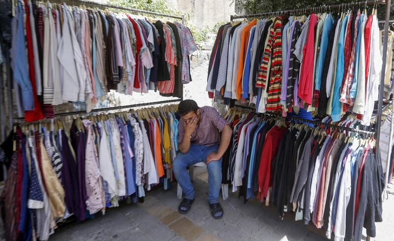 A Syrian man waits for customers at a second-hand clothes shop at a flea market in the capital Damascus, Syria. AFP