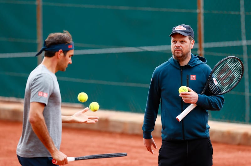 Roger Federer and coach Severin Luethi during training. Reuters