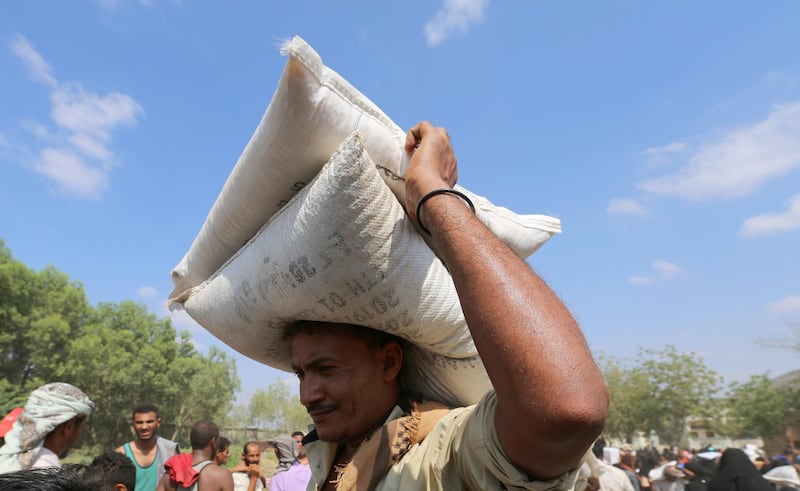 A man carries sacks of grain he received from an ICRC aid distribution centre in Bajil, Yemen December 13, 2018, 2018. Picture taken December 13, 2018. REUTERS/Abduljabbar Zeyad