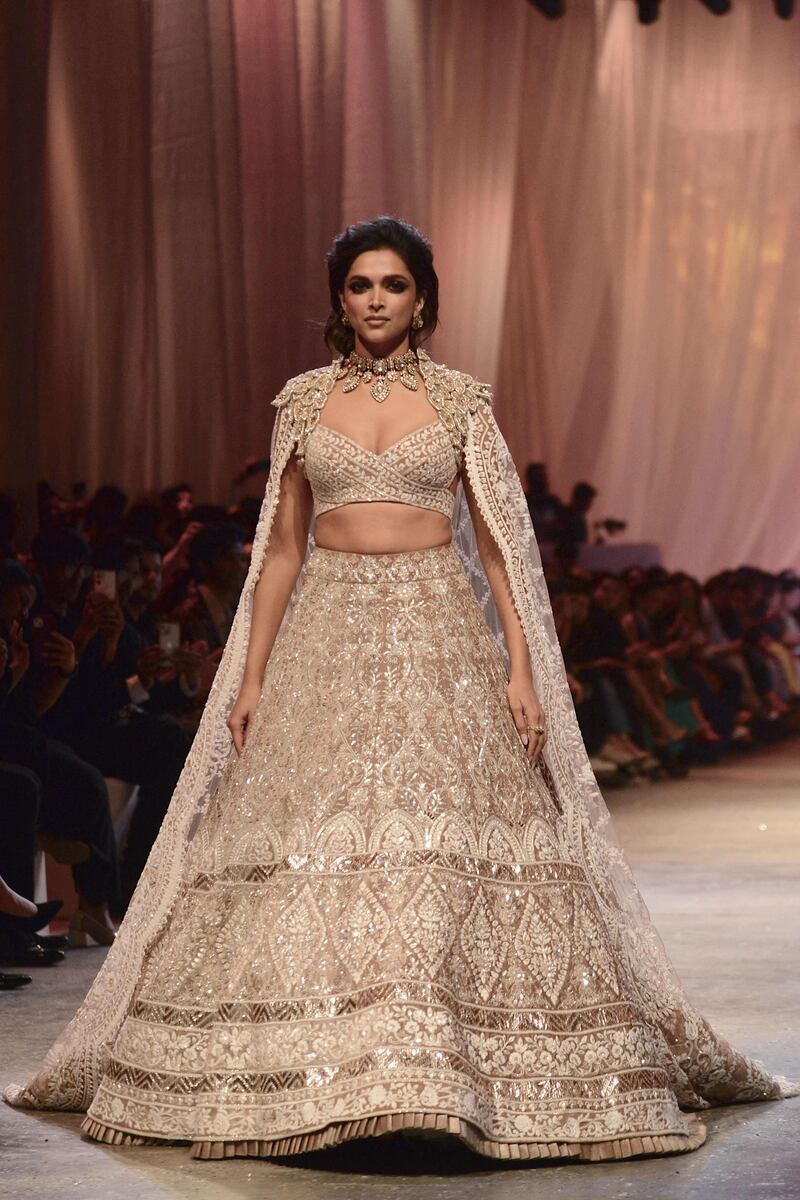 Padukone wore a heavily embellished lehenga with matching blouse and plunging neckline, topped off with a cape.