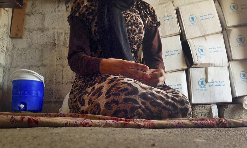 A Yazidi girl, 15, captured by ISIS and forcibly married to a militant in Syria, sits on the floor of a one-room house she now shares with her family. AP