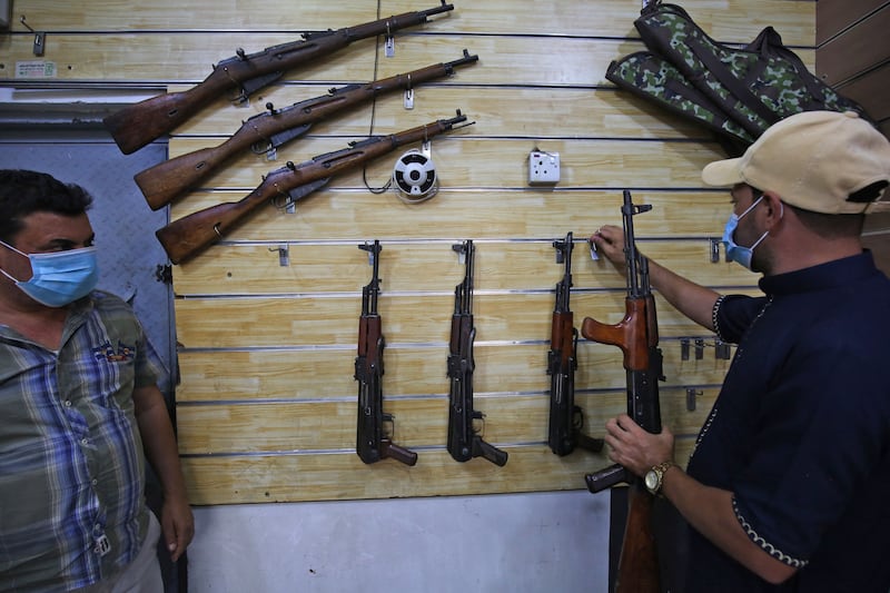 Employees display rifles for sale at a gun shop in the Iraqi capital Baghdad. AFP