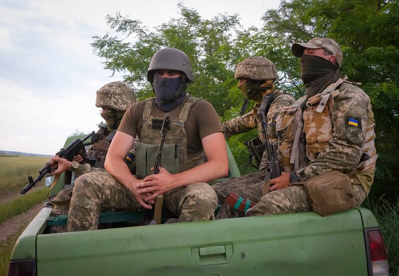 A Ukrainian special operations unit sits in the back of a pick-up truck after a combat operation in the country's east. AP