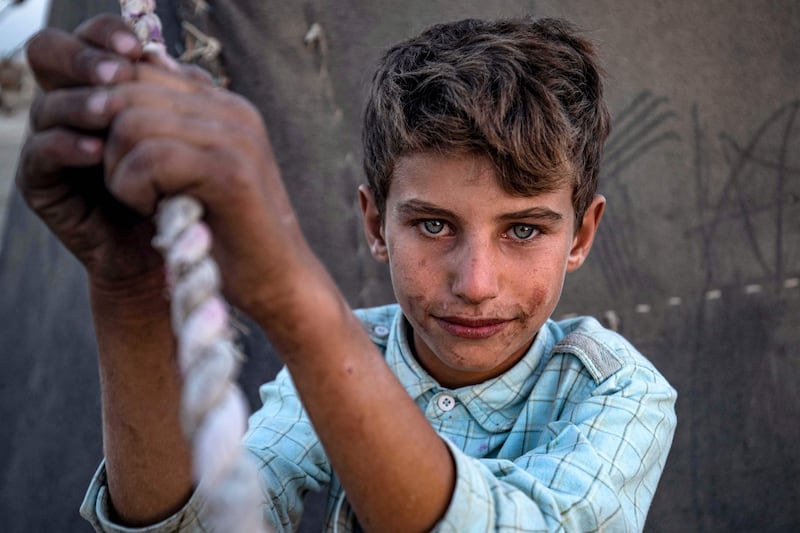 A Syrian boy at the Yunani camp for Syrians displaced by conflict in the countryside of Raqa, Hamah and other regions along the banks of the Euphrates river in Syria's northern province of Raqa. AFP