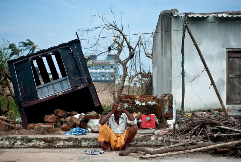 Bhagwan, a coconut-seller, sits in front of his destroyed shop in Gopalpur after Cyclone Phailin left a trail of destruction along India's east coast. Manan Vatsyayana / AFP