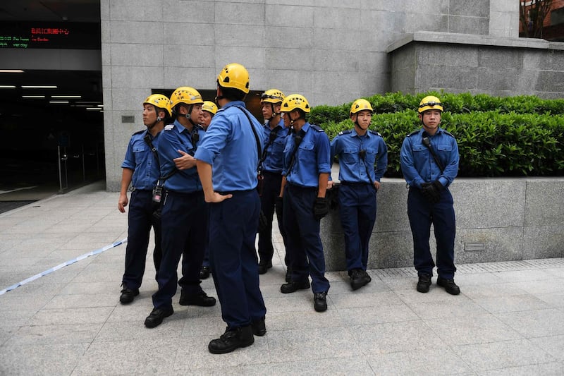 Emergency services personnel wait as Robert climbs the building. AFP