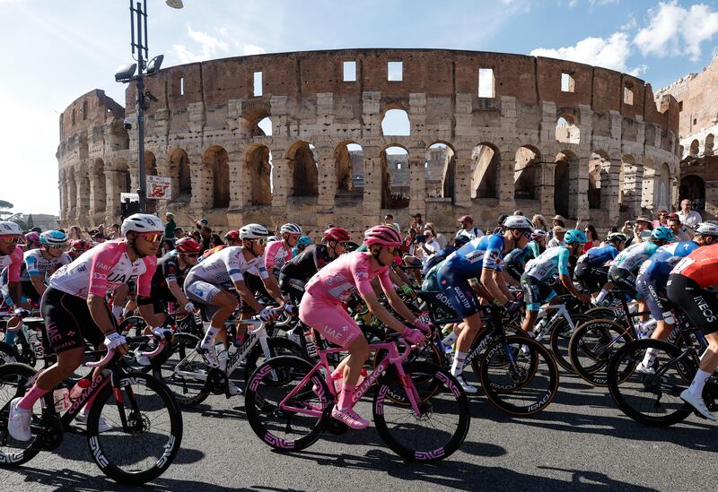 Slovenian rider Tadej Pogacar of UAE Team Emirates, centre, and the peloton pass the Colosseum in Rome. EPA
