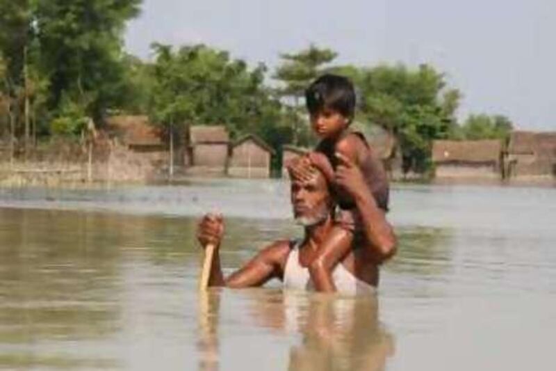 Akbar Shaikh, has not left his village of Pattarwah, in Supaul district, although the water level has risen. After water level rose to 5 feet with his wife and children he took shelter on the roof of a mosque in the middle of the village. "There are flood pirates around. Everyday 2 or 3 times I go to check my house which is located at end of the village, in the middle of this sea of water," said the 45-year-old man on his way back from his house. Here he is caring his youngest daughter Rezina.

Credit: Shaikh Azizur Rahman for The National