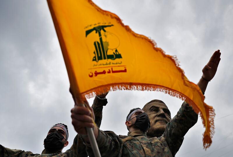 Hezbollah fighters stand in front of a statue of Iranian General Qassem Suleimani in Beirut, Lebanon. AP