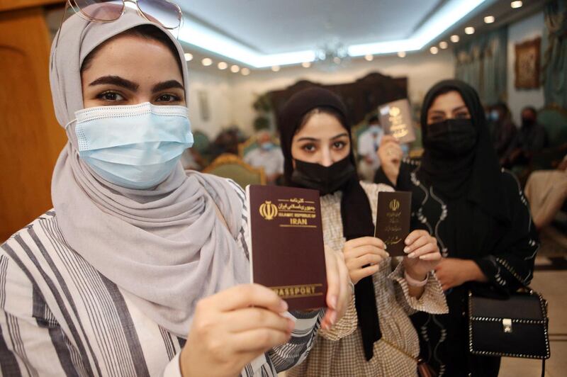 Iranians show their passports as they queue to vote in the the Islamic republic's presidential election at a polling station in Kuwait City. AFP
