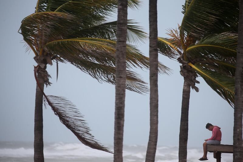 A man sits on a lifeguard tower as Hurricane Irma blows into Florida. Carlo Allegri / Reuters