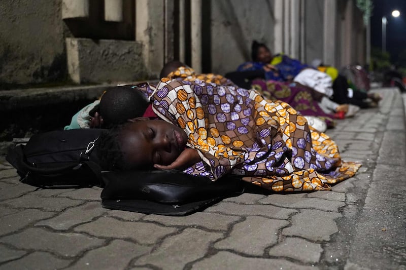 Goma residents sleep on the pavement in Gisenyi, Rwanda, after fleeing their homes across the border in the DRC when Mount Nyiragongo erupted. AFP