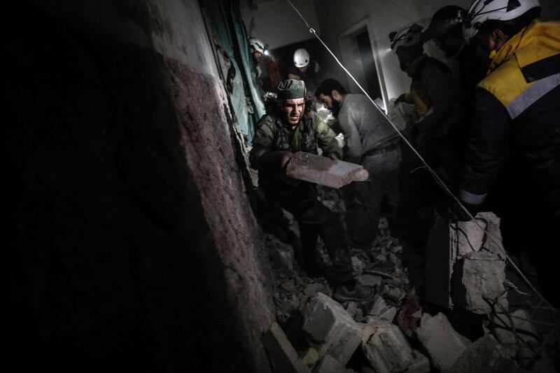 Syrian civil Defence volunteers and civilians search for survivors inside a building following an explosion in the rebel-held city of Idlib. Sameer Al-Doumy / AFP