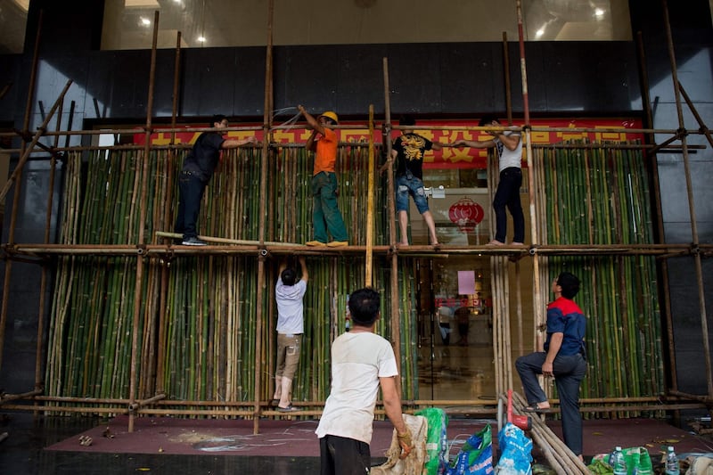 Workers set up a protective structure at the entrance of a hotel in Guangdong. AFP