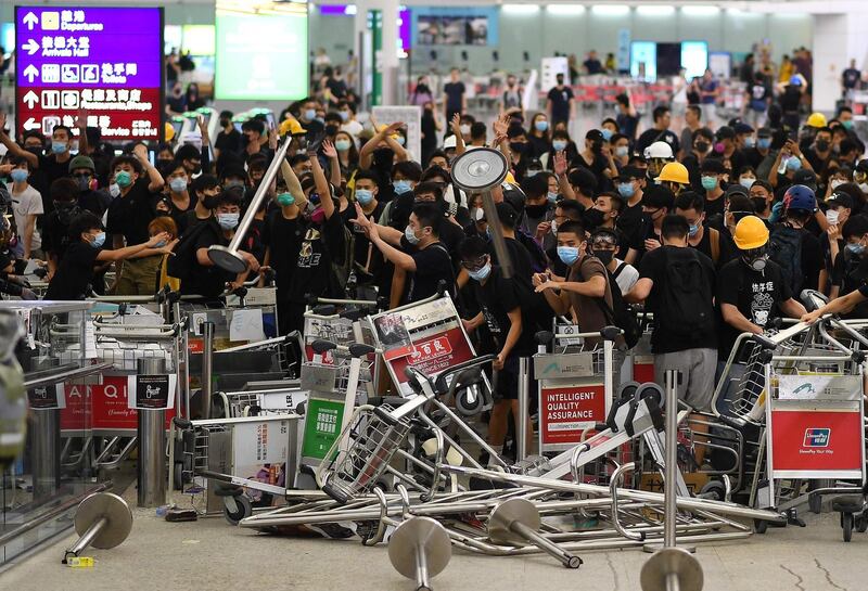 Pro-democracy protestors block the entrance to the airport terminals with luggage trollies after a scuffle with police at Hong Kong's international airport. AFP