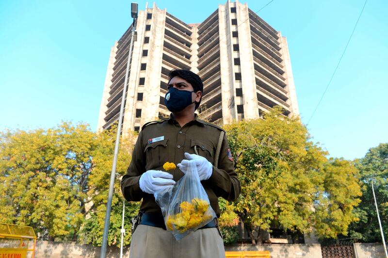 A policeman holds flowers to distribute to people in a bid to inspire them to stay home. AFP