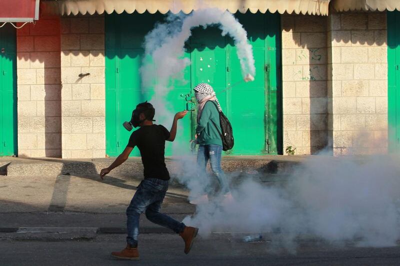 A Palestinian protester uses a slingshot to throw back a tear gas canister towards Israeli security forces during clashes on October 15, 2015 in the West Bank city of Bethlehem. Musa Al Shaer/AFP Photo

