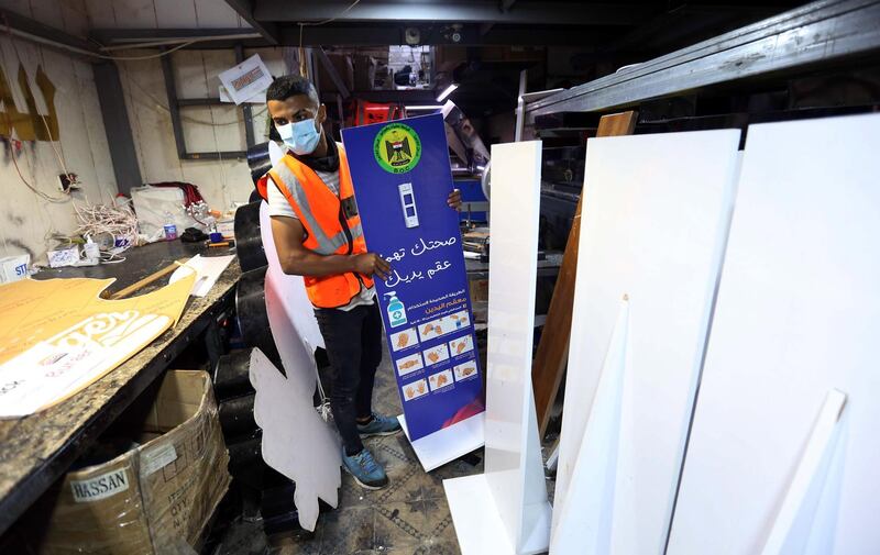 An Iraqi printer works on signs with coronavirus guidelines in Baghdad. EPA