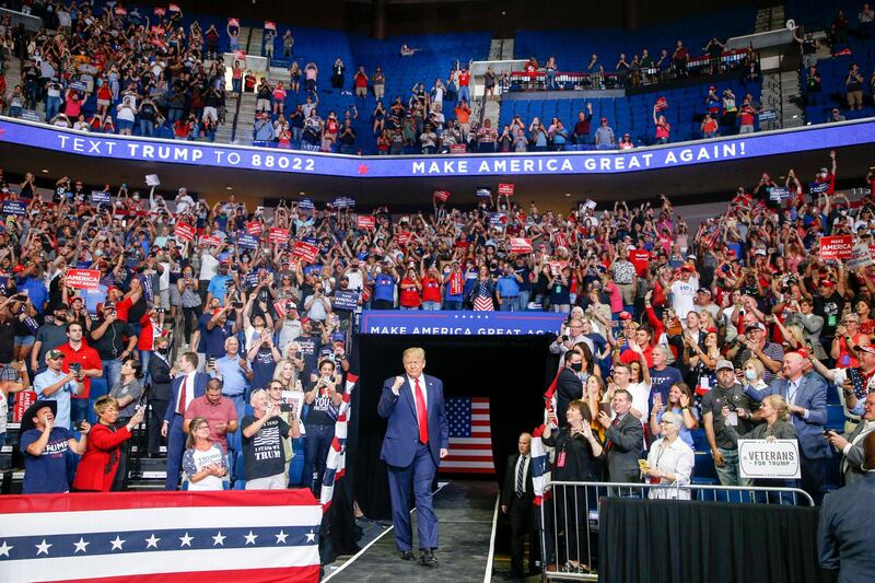 US President Donald Trump, centre, walks toward the stage while supporters cheer during his campaign rally at Bank of Oklahoma Center in Tulsa, Oklahoma, US. Tulsa World via AP