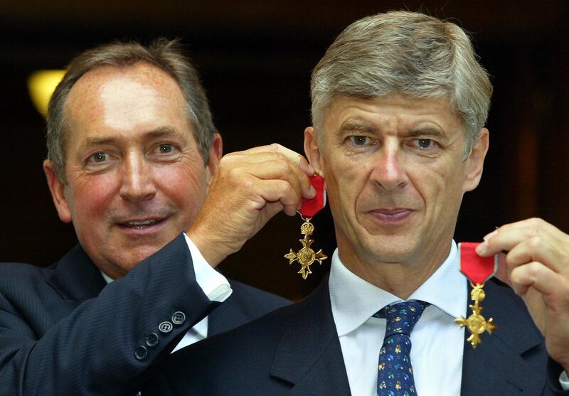 Pictured on July 9, 2003 Gerard Houllier (L) of Liverpool holds his OBE medal as an earring on long-term friend and fellow manager Arsene Wenger of Arsenal, after being awarded their OBE medals at The Foreign Office in London. Adrian Dennis / AFP